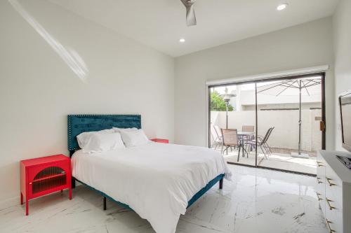 Dormitorio blanco con cama y taburete rojo en Palm Springs Condo with Pool Access Near Downtown!, en Palm Springs