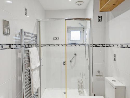 a white bathroom with a shower and a toilet at Family Home in Rustington, West Sussex in Rustington