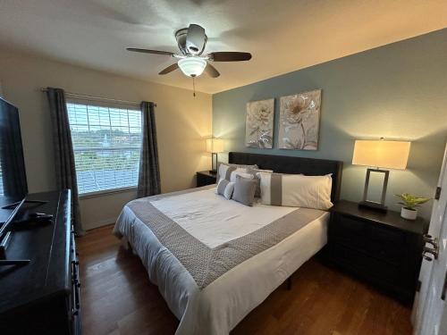 1 dormitorio con 1 cama grande y ventilador de techo en NEW! Lakefront Views- Encantada Resort Townhouse, en Kissimmee