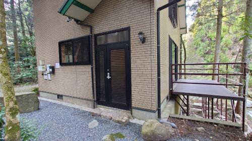 にあるRyukyo no Sato Auto Campsite - Vacation STAY 42105vの黒い扉とベンチのある家