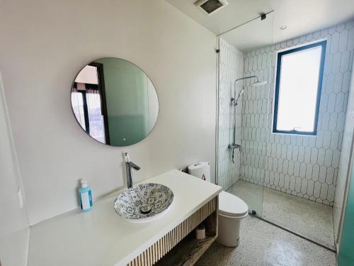 a white bathroom with a sink and a mirror at Villa de Lumiere - đô thị thượng lưu Swanbay, Đại Phước 330m2 với 6 phòng ngủ tiện nghi in Nhơn Trạch