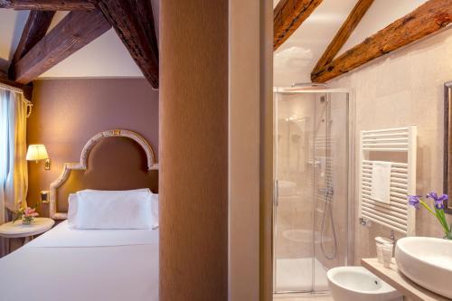 a bedroom with a bed and a shower and a sink at Residenza Venezia | UNA Esperienze in Venice
