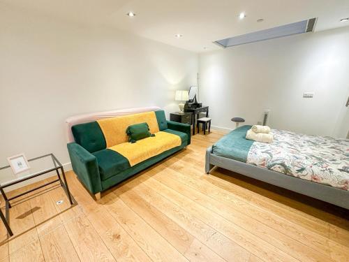 ein Schlafzimmer mit einem Bett, einem Sofa und einem Schreibtisch in der Unterkunft Bright, spacious, 3-bedroom Emirates apartment with terrace in London