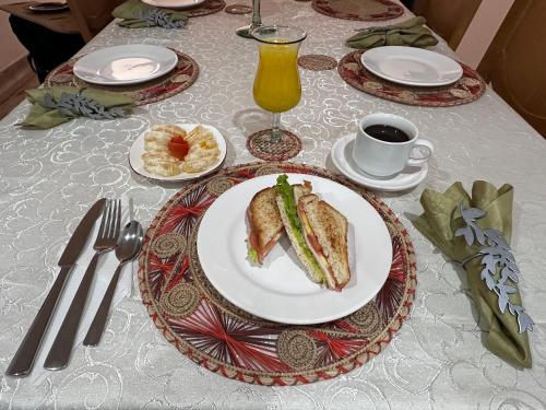 a table with a plate of sandwiches and a cup of coffee at HOTEL SANTA ANA LUXURY RENTALS in Bogotá