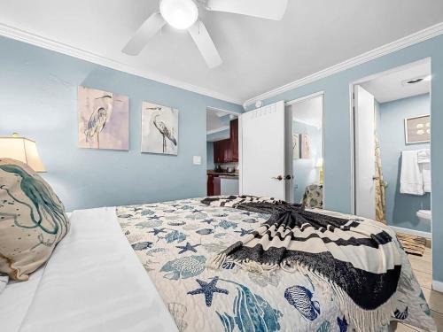 a bedroom with a bed and blue walls at Seaclusion Updated condo steps to beach & bay in Bradenton Beach