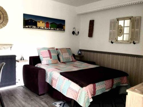 une chambre avec un lit avec une couette dessus dans l'établissement Le jardin de la mer, plage, jardin, parking , vélos, à Villeneuve-Loubet