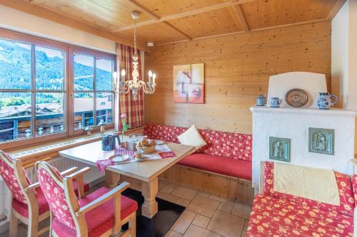 a dining room with a table and a fireplace at Landhaus Schenk Rotspitze in Bad Hindelang
