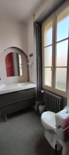 a bathroom with a sink and a toilet and a mirror at Hôtel Restaurant Le Moulin de la Renne Adults Only proche Zoo de Beauval in Thésée