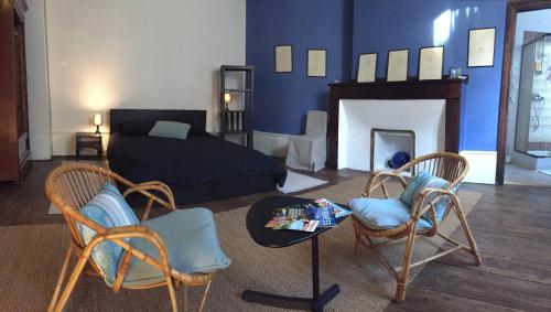 een woonkamer met een bed en twee stoelen en een tafel bij Au détour Du Larrech in Castillon-en-Couserans