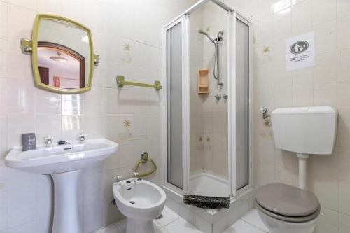 ein Bad mit einem WC, einem Waschbecken und einer Dusche in der Unterkunft Roulito's House in Altura