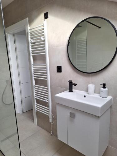 a bathroom with a white sink and a mirror at Apartman Star #2 in Vinkovci