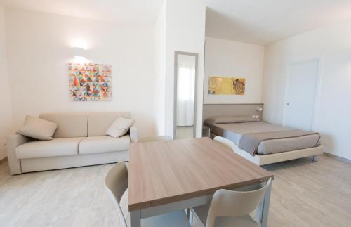 a living room with a couch and a bed and a table at La Blanca Resort & Spa in Castellammare del Golfo