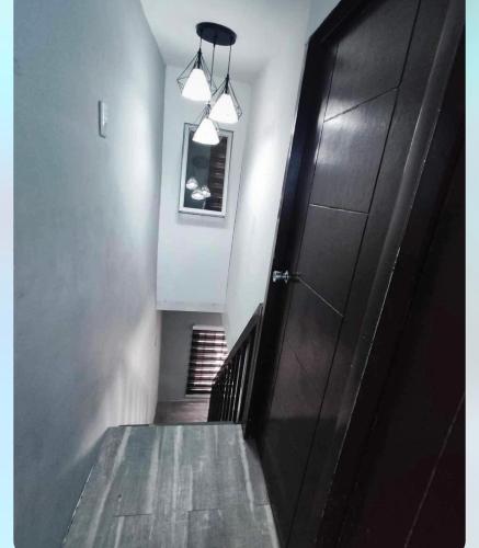 a hallway with a black door and a stairway at Vacation Home / Short Term Rent 