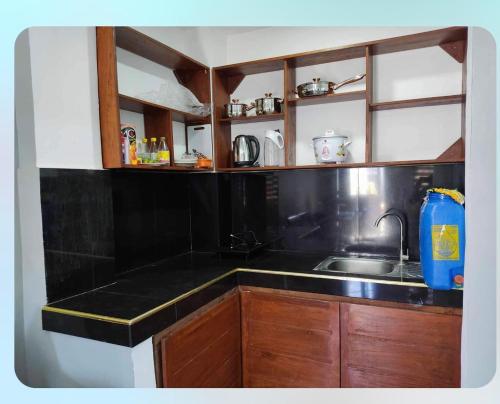- une cuisine avec un évier et un comptoir noir dans l'établissement Vacation Home / Short Term Rent, 
