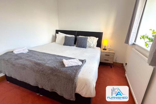 a bedroom with a large bed and a window at Contractor Stays by Furnished Accommodation Leeds - Free Van Parking on Driveway in Bramhope