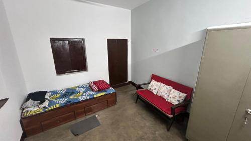 um quarto com uma cama, uma cadeira e uma janela em Debnath Homes em Jamshedpur
