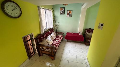 uma sala de estar com um sofá e um relógio na parede em Debnath Homes em Jamshedpur