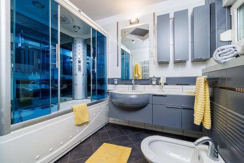 a bathroom with a sink and a tub and a toilet at Apartmani Višnja in Crikvenica