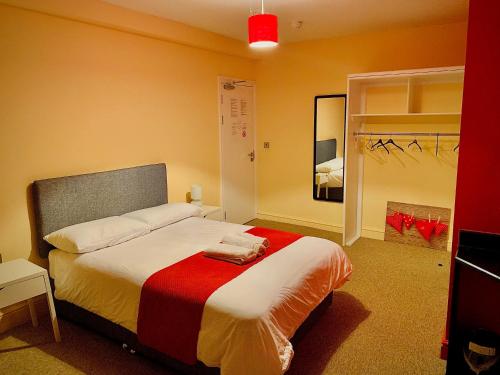 a bedroom with a bed with a red blanket on it at Prince Apartment Inn in Norwich