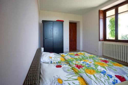 um quarto com uma cama com um cobertor floral em App 1 per famiglie con splendida vista lago em Belgirate