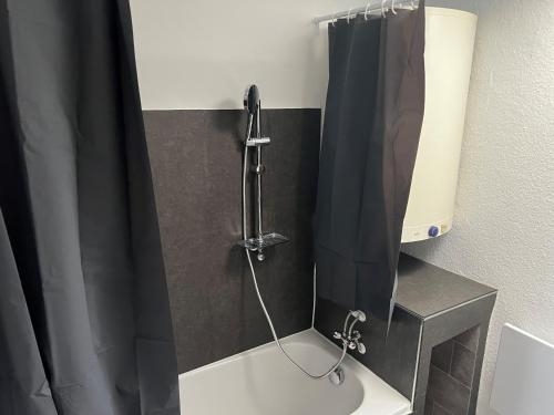 La salle de bains est pourvue d'une douche avec rideau de douche noir. dans l'établissement Mesek Pension, à Oberasbach