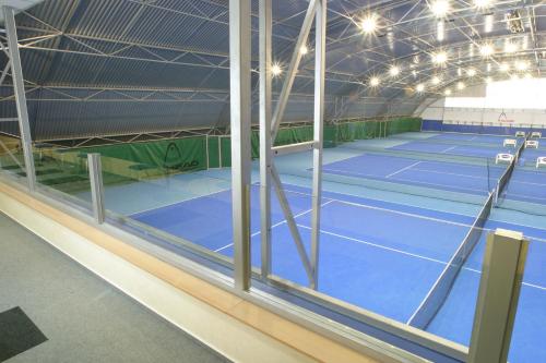 a tennis court inside of a building with windows at Sporthotel Vestec in Vestec