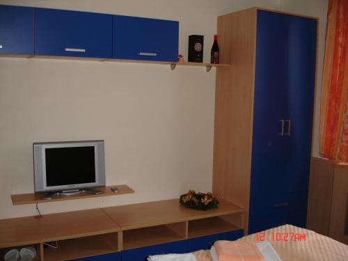 a bedroom with blue cabinets and a tv on a shelf at Sporthotel Vestec in Vestec