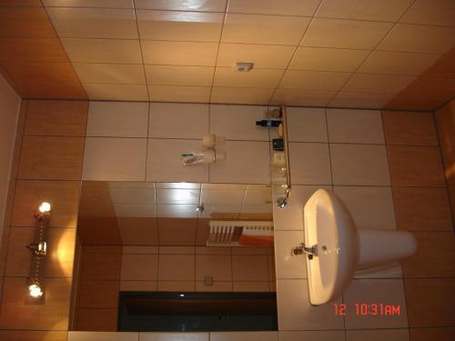 a bathroom with a urinal on a tiled wall at Sporthotel Vestec in Vestec