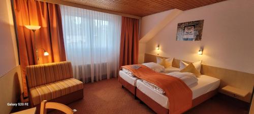 une chambre d'hôtel avec un lit et une chaise dans l'établissement Hotel Restaurant Ruppert, à Walluf