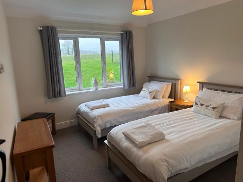 two beds in a room with a window at South Downs Rural Retreats in Worthing