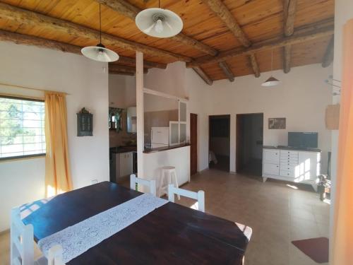 a dining room and kitchen with a table and chairs at Casas HG-Acepta mascotas-Desayuno sencillo-Pileta climatizada en predio a 2 kilómetros in Huerta Grande