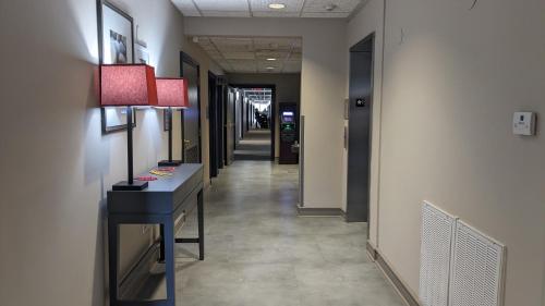 a hallway with a desk with a lamp and a hallway with a hallway sidx sidx at Country Inn & Suites by Radisson, Covington, LA in Covington