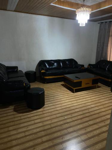 a living room with a black leather couch and a coffee table at Golden motel in Gisenyi