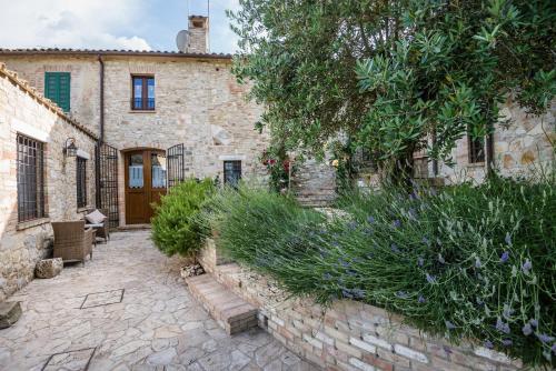 a stone house with a courtyard and a building at BorgoCuore in Todi