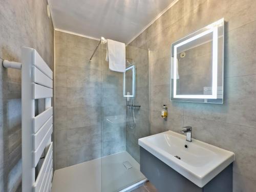 a bathroom with a sink and a shower and a mirror at Logis Le Prieuré in Locronan