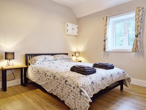 a bedroom with a bed and a window at The Stables, Wickham in Shedfield