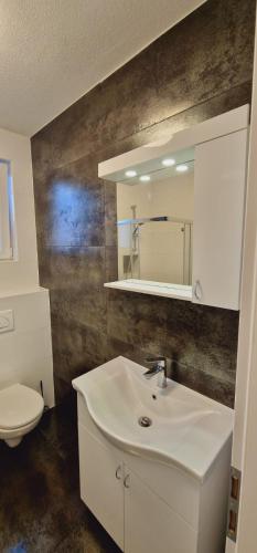 een badkamer met een witte wastafel en een toilet bij ANTODO Ivana in Novalja