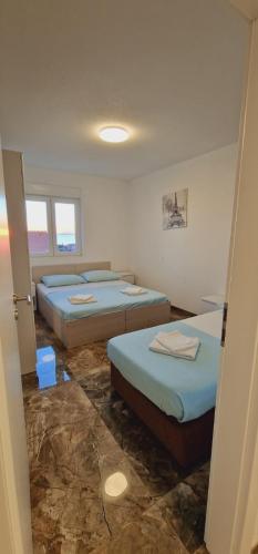 een kamer met drie bedden in een kamer bij ANTODO Ivana in Novalja