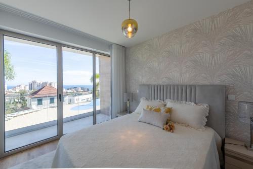 a bedroom with a large bed and a large window at The Queen Apartment By Sam Houses in Funchal