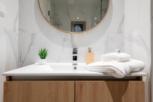 a bathroom with a sink with a mirror and towels at The Queen Apartment By Sam Houses in Funchal