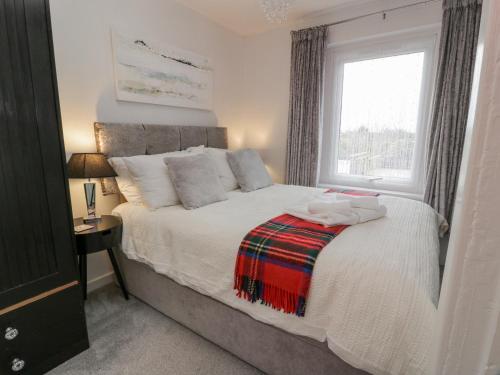 1 dormitorio con 1 cama grande y ventana en Rosalin Cottage en Irvine