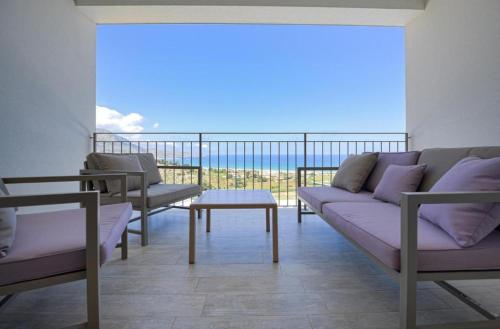 a living room with a couch and a table on a balcony at La Blanca Resort & Spa in Castellammare del Golfo