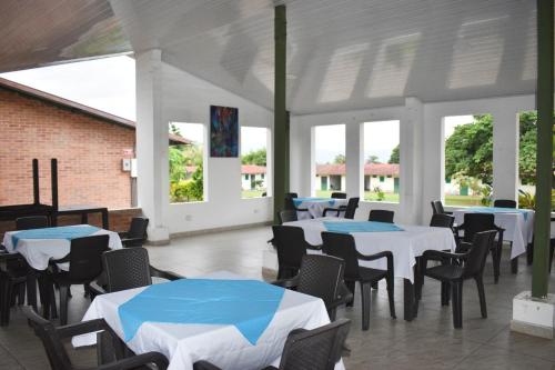 een eetkamer met tafels, stoelen en ramen bij Hotel Estambul in Los Guayabos