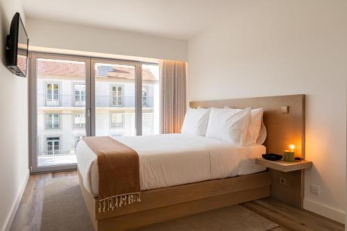 a bedroom with a large bed and a large window at Host Wise - Fervença Boutique Palace in Vila Nova de Gaia