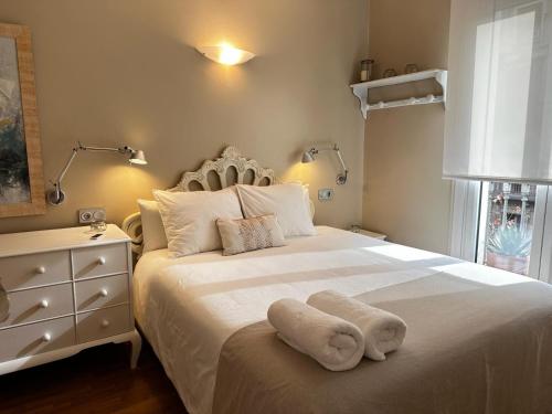 a bedroom with a white bed and a dresser at Petit Rosselló in Barcelona