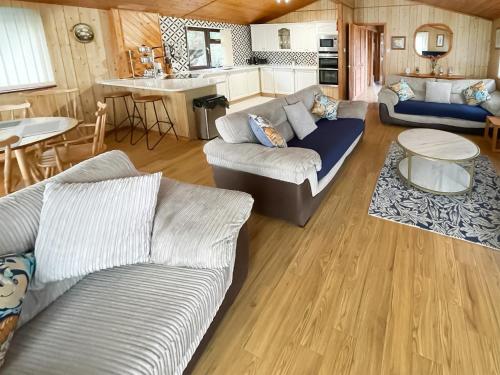 ein Wohnzimmer mit 2 Sofas und einer Küche in der Unterkunft The Hive in Warmwell