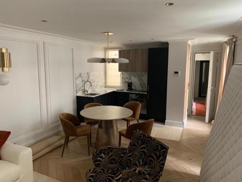 une cuisine et une salle à manger avec une table et des chaises dans l'établissement L'appartement Des Arts, à Paris