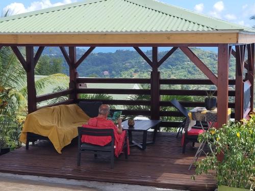 a man sitting in a gazebo on a deck at Ericka et François in Quartier Monplaisir