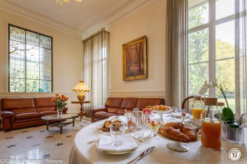 un salon avec une table avec de la nourriture dessus dans l'établissement Château des Métairies, à Pougues-les-Eaux