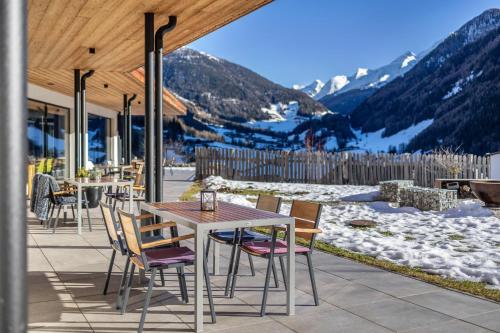 a patio with a table and chairs and a mountain at Stoana Apt 3-4 in San Giacomo